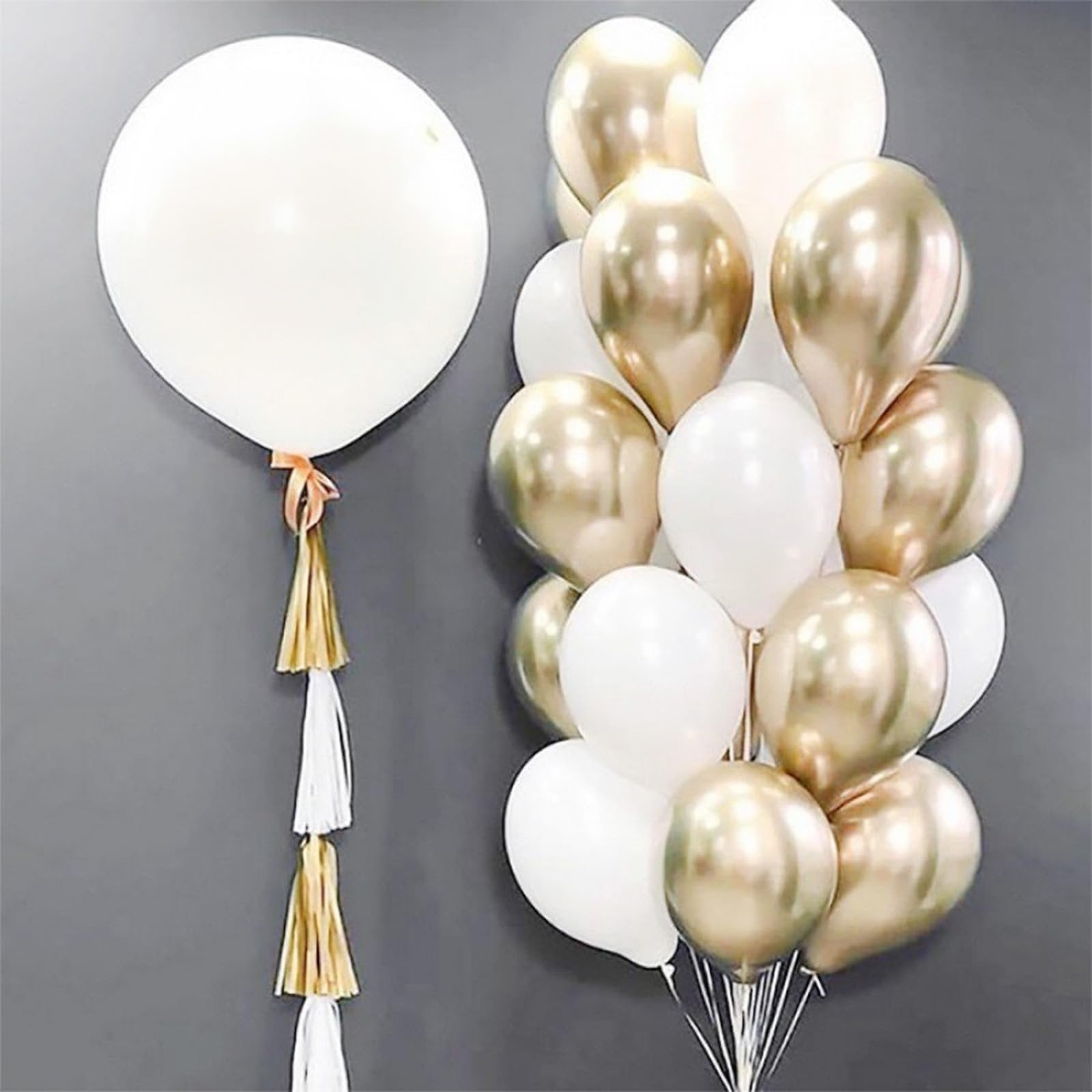 White and gold latex balloons with tassels against a gray background