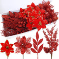 Collection of red glitter artificial poinsettia flowers, leaves, and berry branches arranged in a white box and displayed separately.