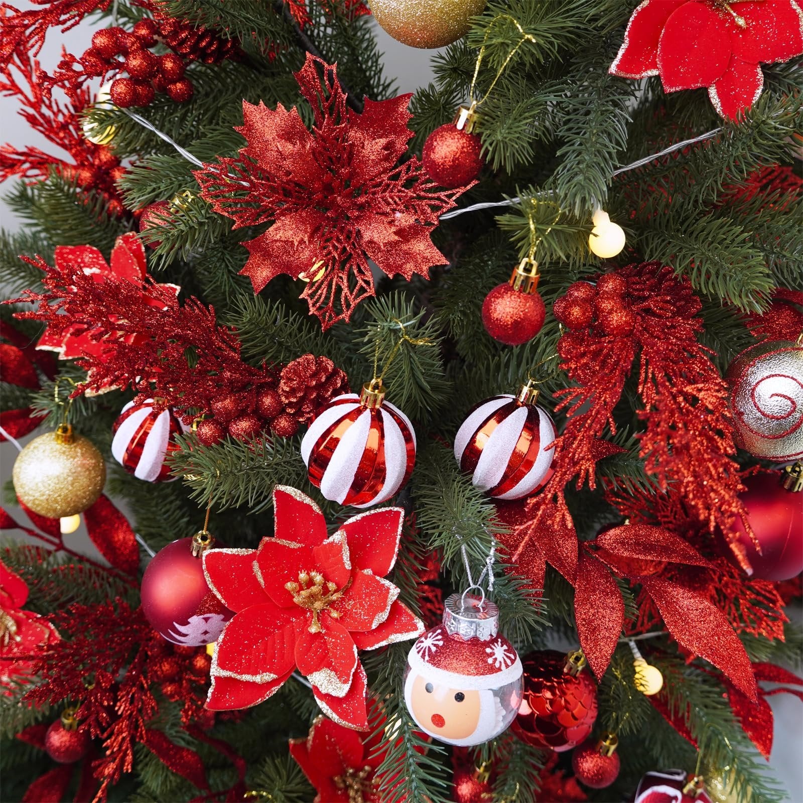 Close-up of a decorated Christmas tree with red glitter poinsettias, ornaments, and lights.