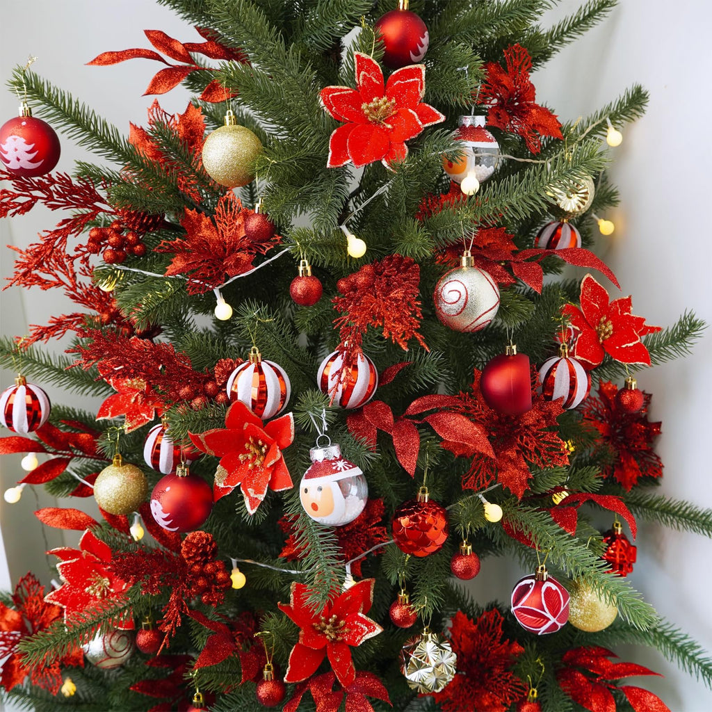 Christmas tree decorated with red glitter poinsettias, gold and red ornaments, and string lights.