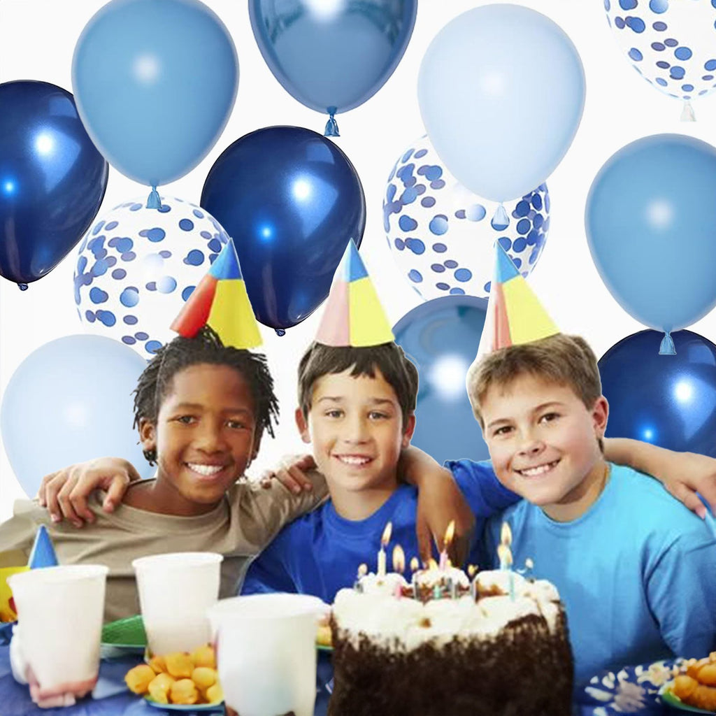 Three smiling boys wearing party hats at a birthday party with a cake and balloons