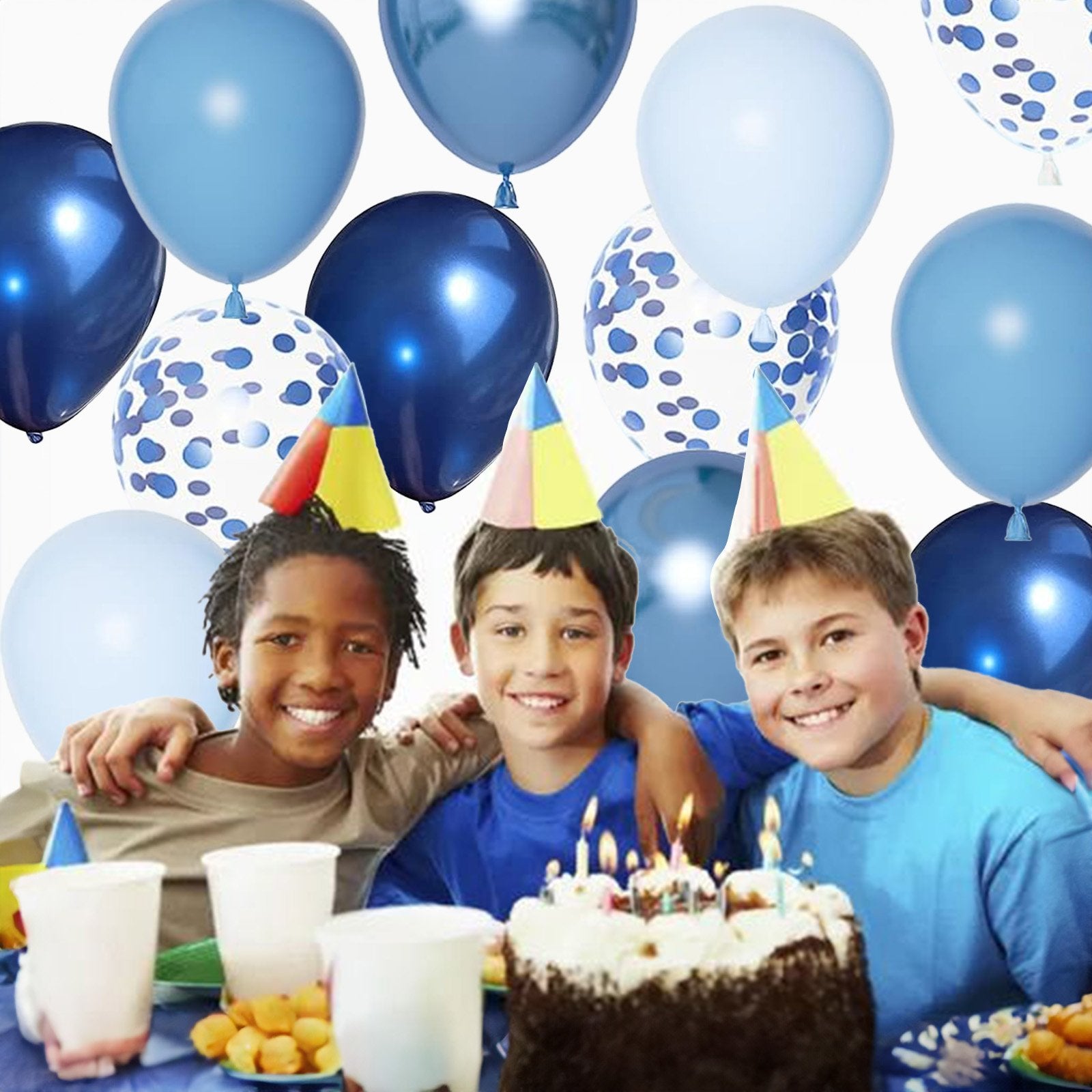 Three smiling boys wearing party hats at a birthday party with a cake and balloons