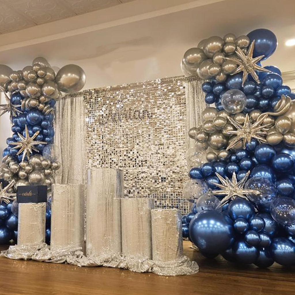 Blue and silver balloon arch with star accents and a sequin backdrop, set up for an event.