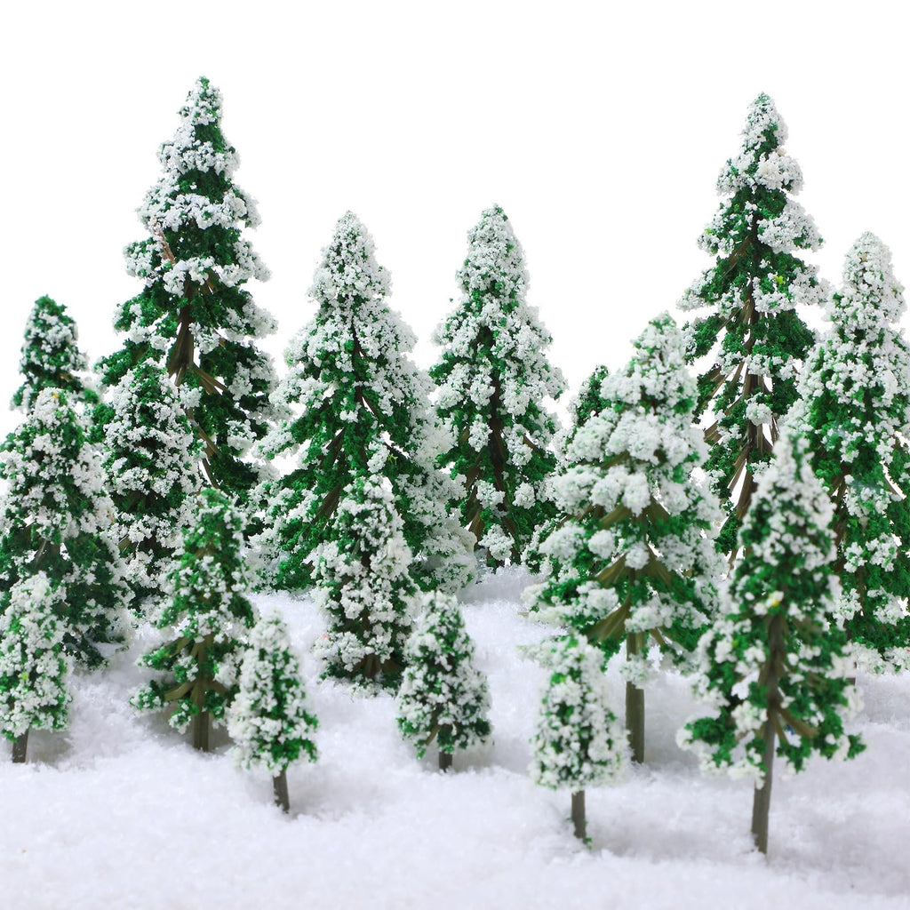 Assortment of miniature green pine trees with white snow flocking, arranged in a snowy landscape against a white background.