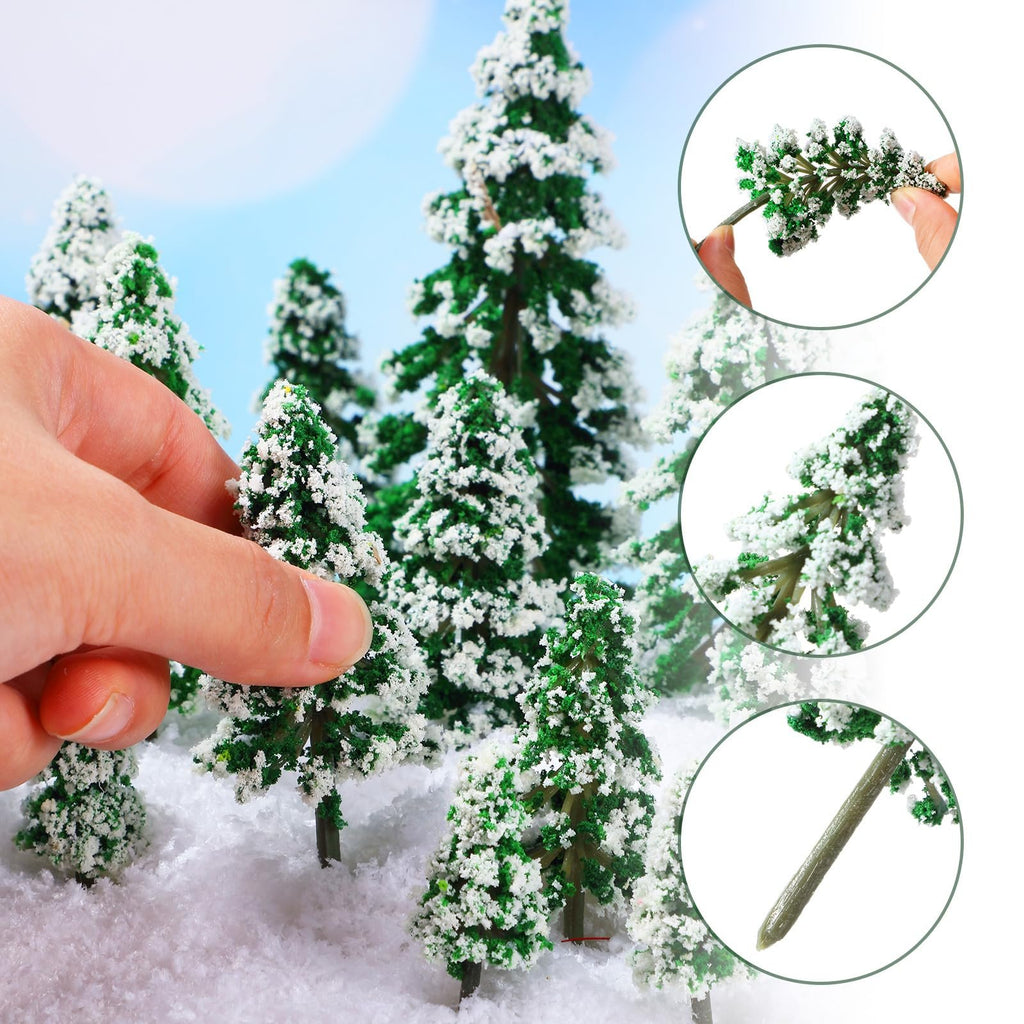 Hand holding a miniature snow-covered pine tree with green foliage and white flocking, surrounded by similar trees in a winter scene.
