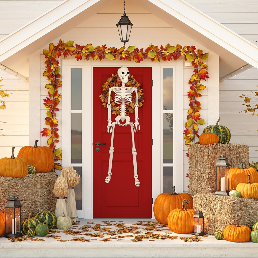Poseable skeleton hanging on a red door with Halloween decorations including pumpkins and fall leaves