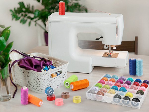 Sewing machine with spools of colorful thread and a bobbin organizer on a table.