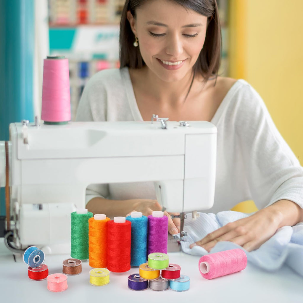 Woman sewing with colorful thread spools and bobbins arranged on a table