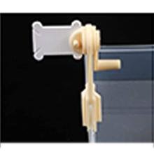 Close-up of a plastic winding mechanism attached to a clear plastic organizer compartment.