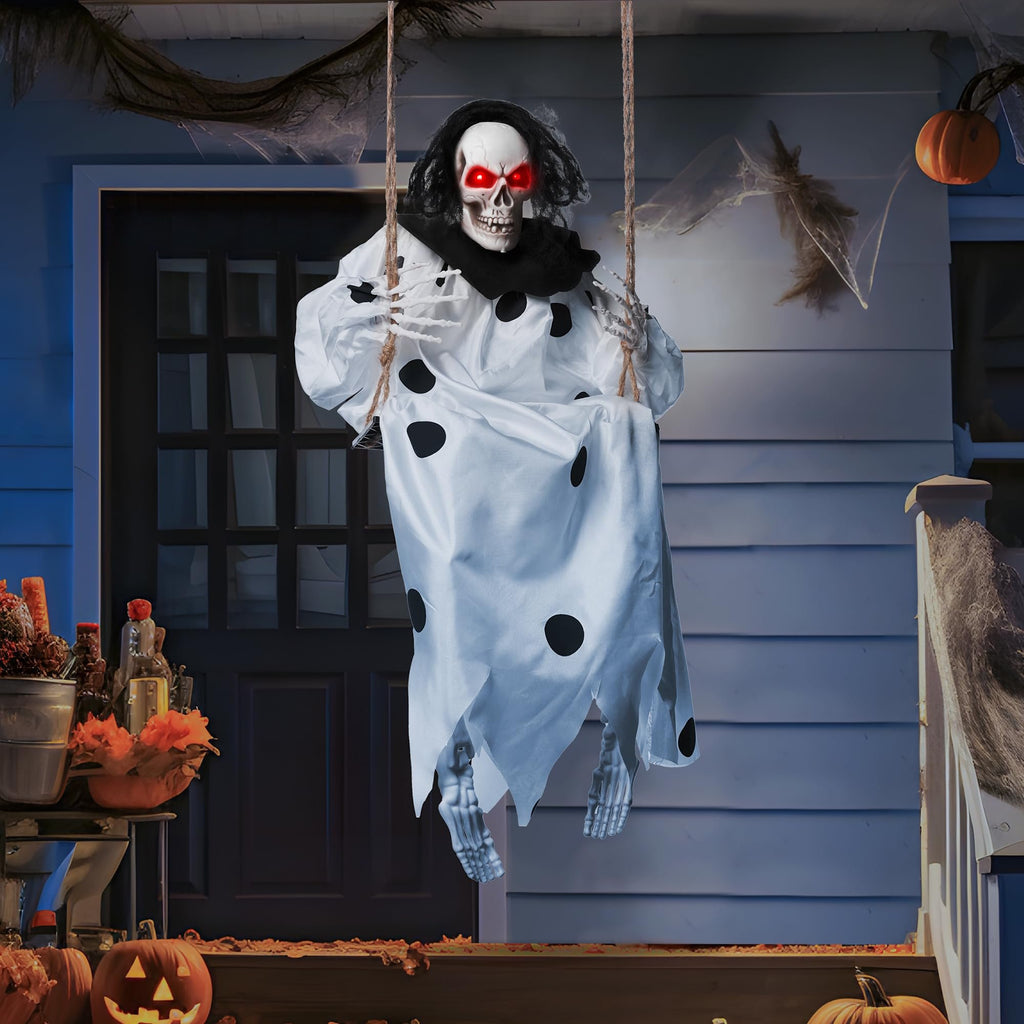 Hanging skeleton prop with glowing red eyes and a polka dot shroud, swinging on a porch for Halloween