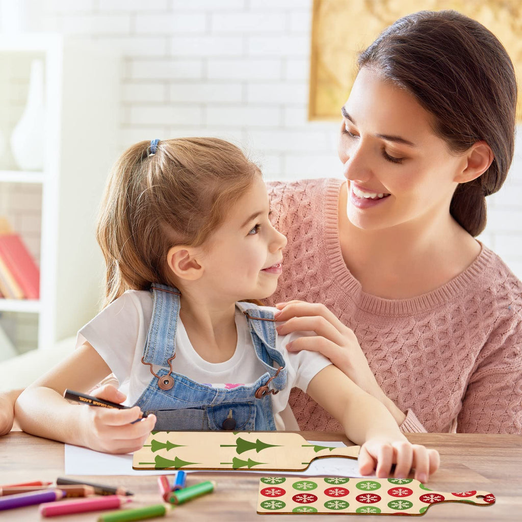 Mother and daughter crafting unfinished wood mini cutting boards with Christmas tree and snowflake designs