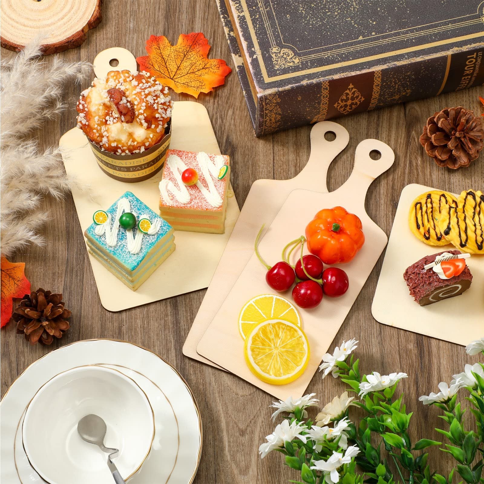 Unfinished wood mini cutting boards with decorative food items and autumn accents on a wooden surface