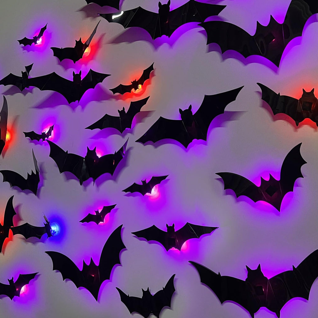 Assorted sizes of black 3D bat wall decor with colorful LED lights illuminating from within, arranged on a light-colored wall.