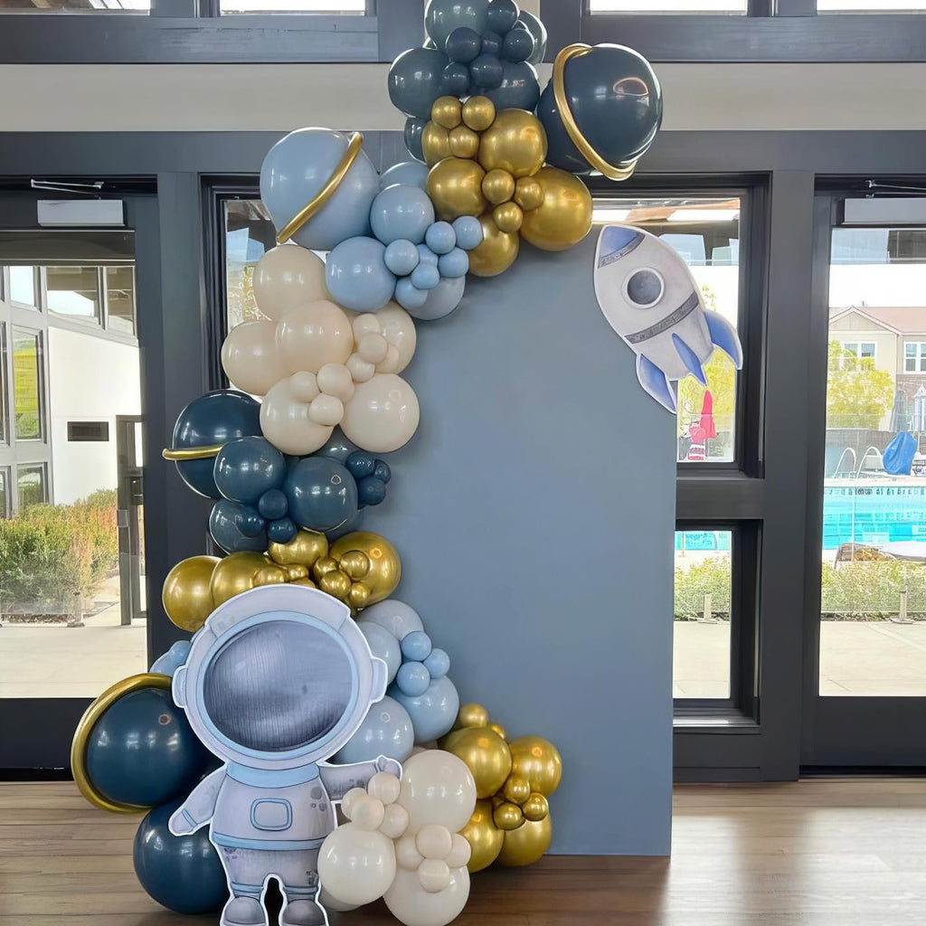 Astronaut cutout and balloon garland with planets and rocket ship decoration