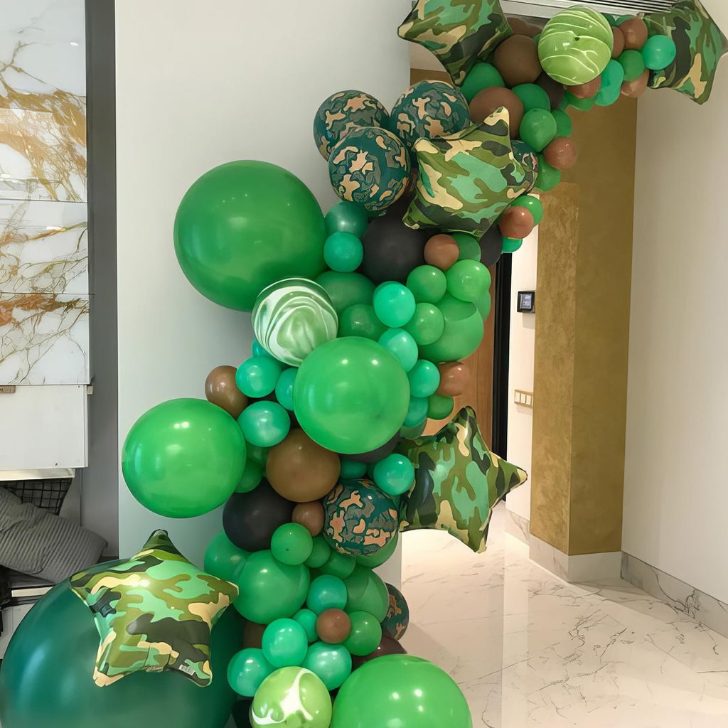 Camouflage and green balloon garland arching over a doorway, featuring star-shaped balloons.