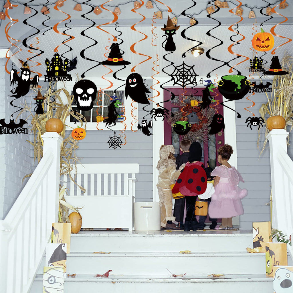 Children in costumes stand on a porch decorated with Halloween hanging swirl decorations.