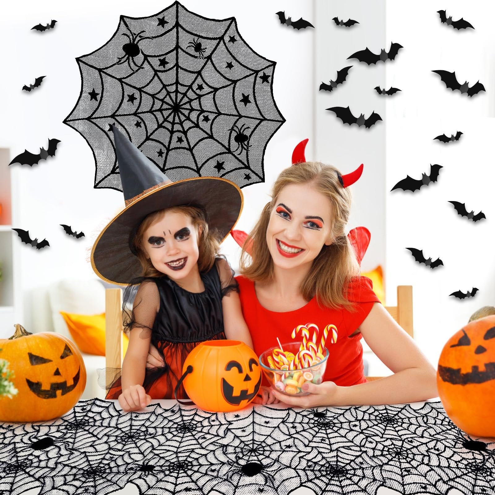 Mother and daughter in Halloween costumes with pumpkins and candy, surrounded by spiderweb and bat decorations.