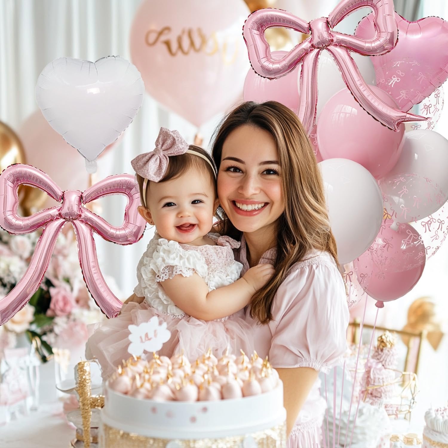 Mother and baby celebrating with pink and white balloons and a cake