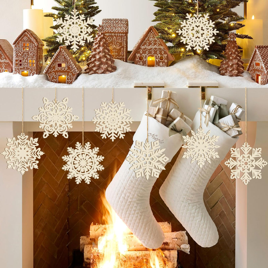 Unfinished wooden snowflake ornaments hanging above a fireplace with stockings and gifts, and on a mantel with gingerbread houses and trees.