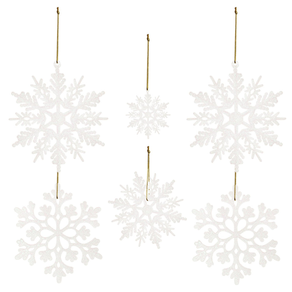 Five white glitter snowflake ornaments of varying sizes hanging by gold strings against a white background.