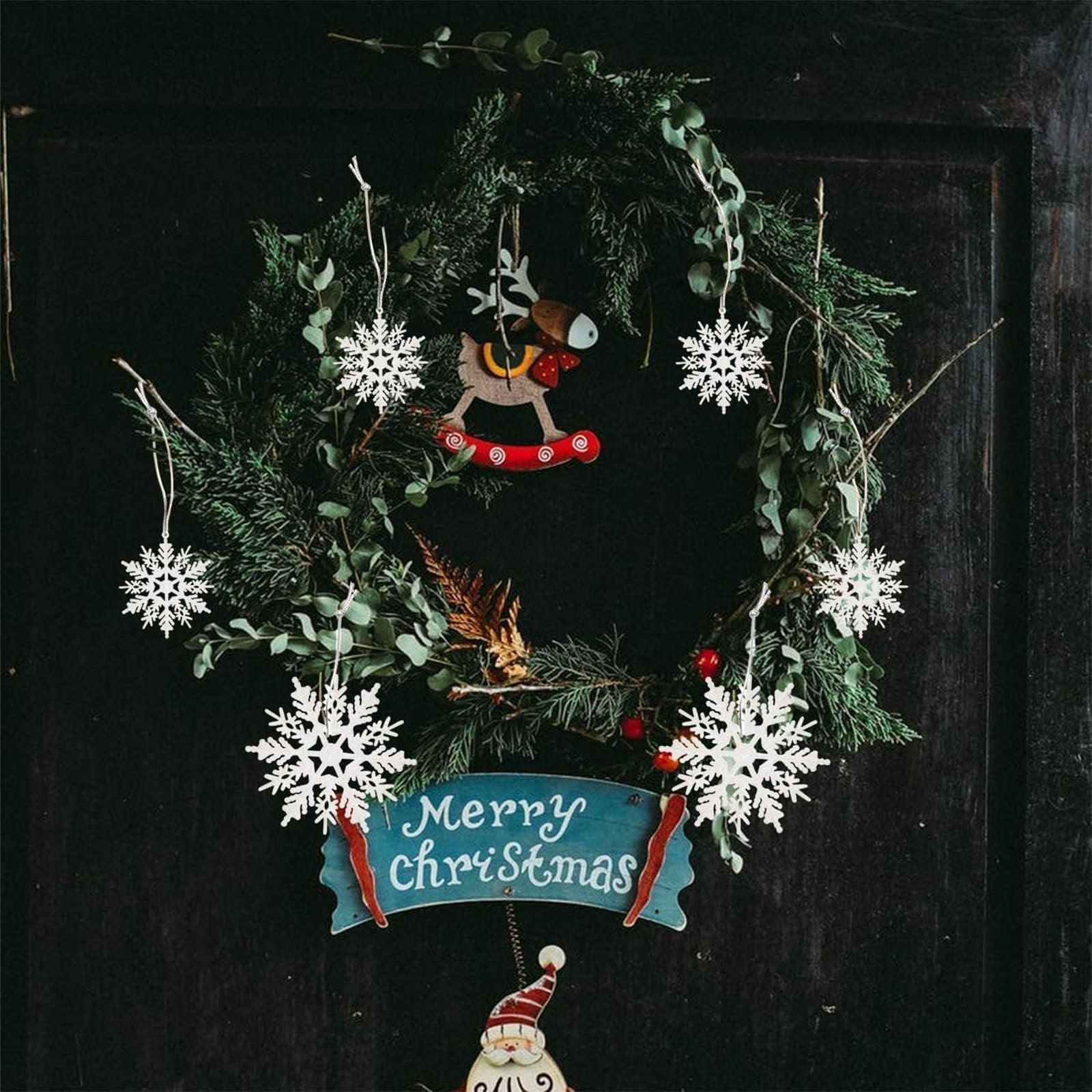 Christmas wreath with white glitter snowflake ornaments and a Merry Christmas sign