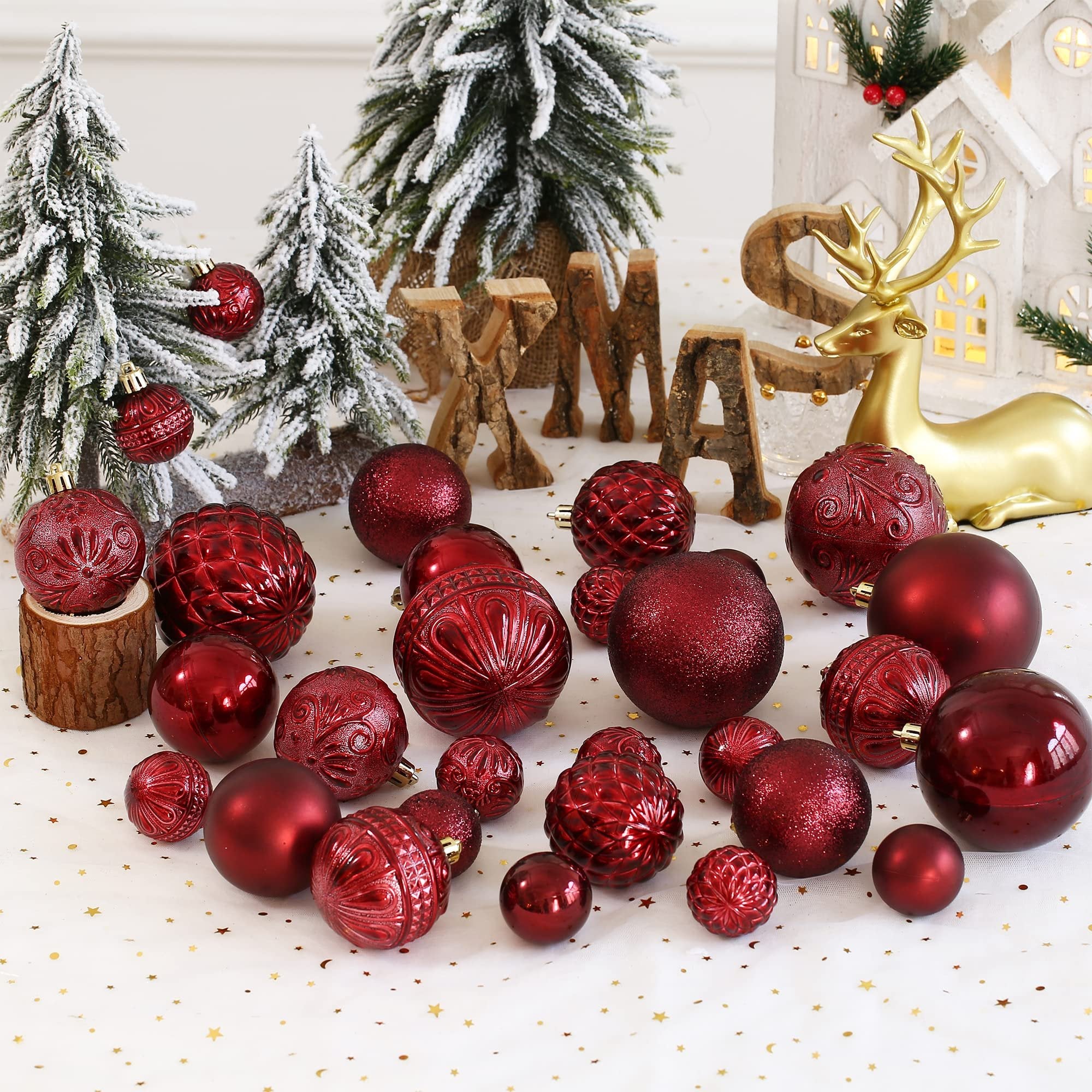 Wine red shatterproof Christmas ball ornaments in various sizes and styles arranged with festive decor.