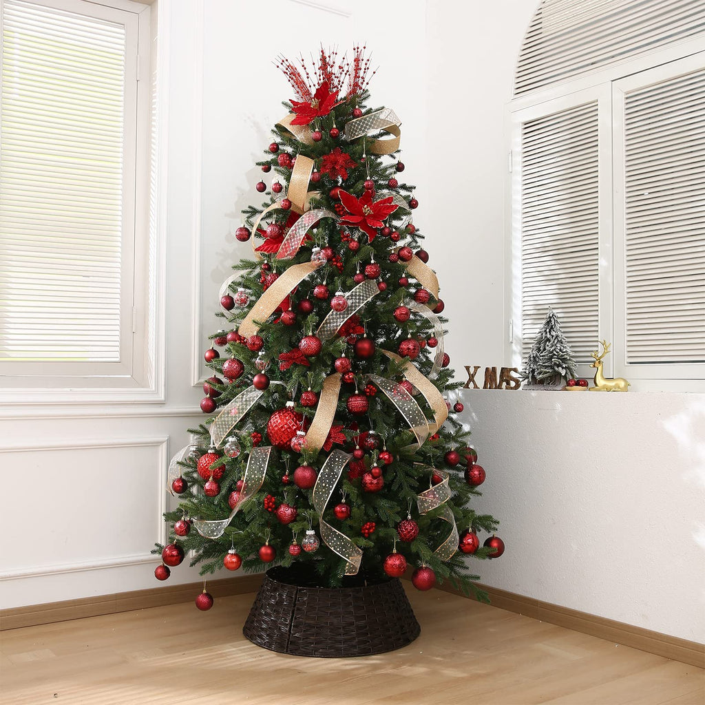 Decorated Christmas tree with red ornaments and gold ribbon, set in a room with windows.