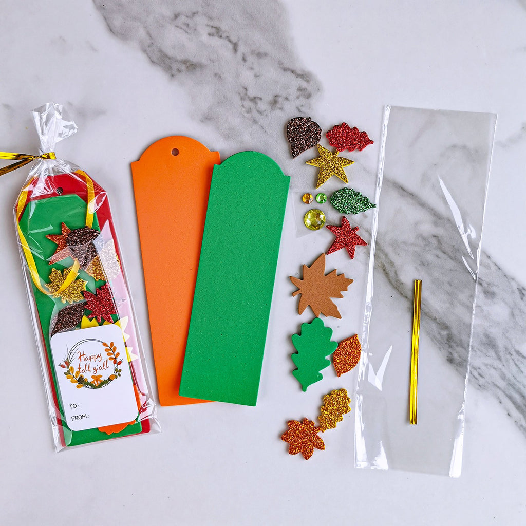 Fall craft kit with foam leaf shapes, glitter stickers, and bookmark bases on a marble background.