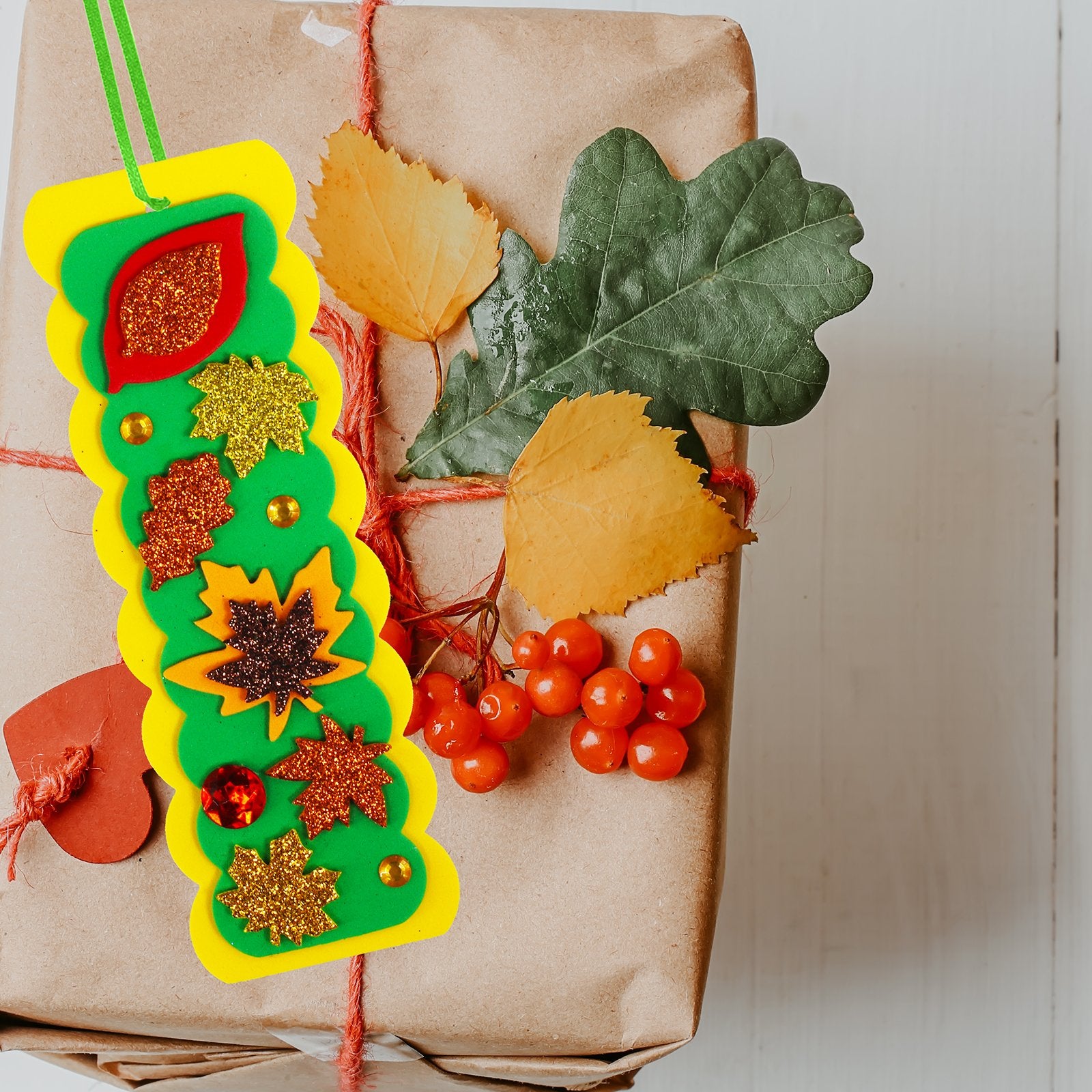 DIY 3D leaf bookmark craft kit with glitter foam stickers and gems on a wrapped gift.