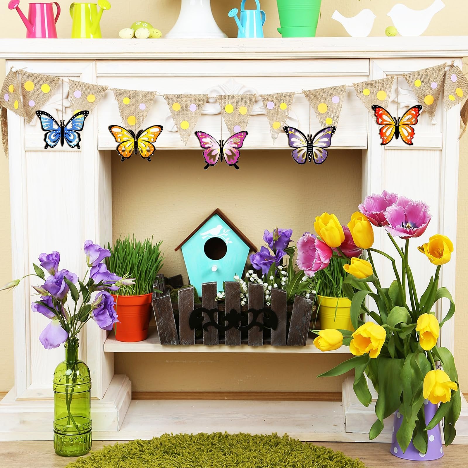 Hanging burlap banner with polka dots and colorful butterfly ornaments, displayed on a white shelf with flowers and a birdhouse.