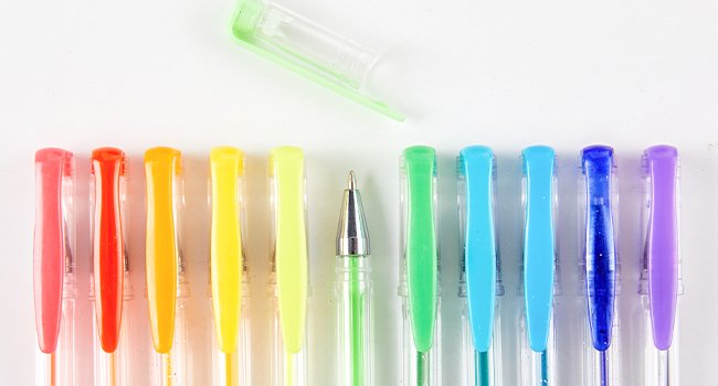 Row of colorful gel pens with caps removed, one pen cap is open at the top