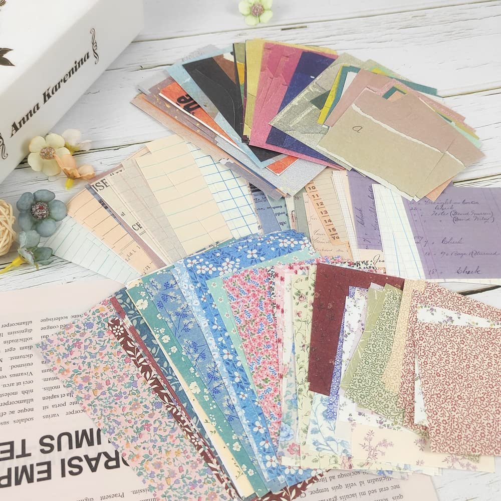 Assortment of vintage scrapbook papers with floral, grid, and text patterns fanned out on a wooden surface.