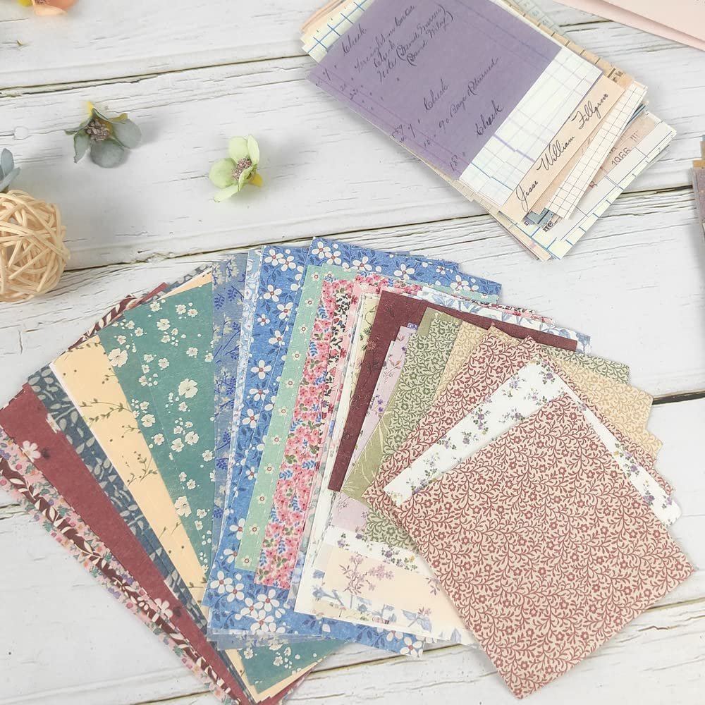 Fan of vintage scrapbook paper sheets with floral and patterned designs, some with ledger-style backgrounds.