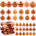 Copper orange Christmas ball ornaments in various sizes and styles, displayed in a clear box and arranged in rows.