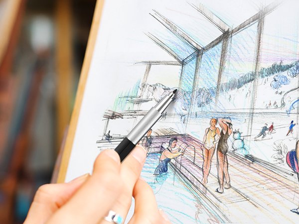 Hand holding a mechanical pencil over a sketch of a building interior with people and a snowy landscape visible through windows.