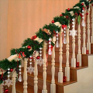 Christmas garland with ornaments draped on a wooden banister, featuring snowflakes, candy canes, and red baubles.