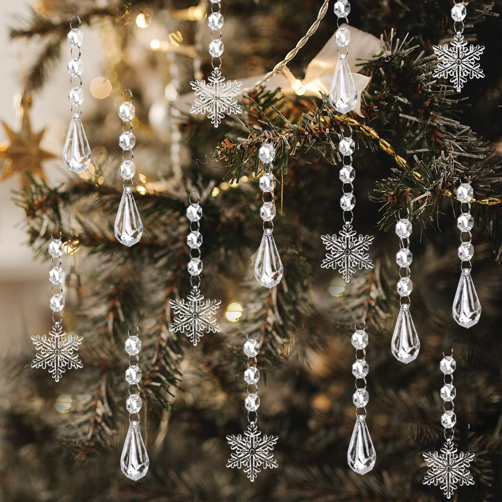 Clear acrylic snowflake and teardrop ornaments hanging on a Christmas tree with bokeh lights.