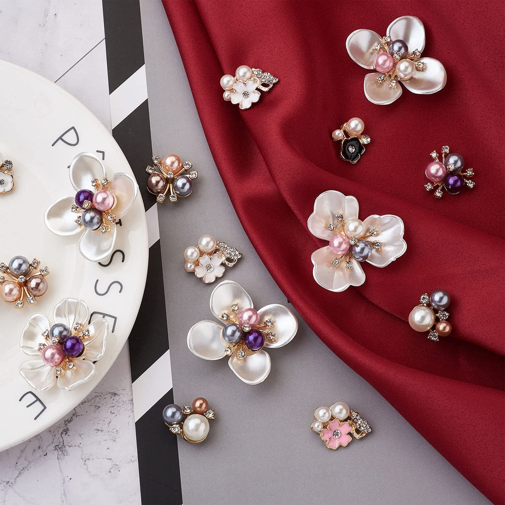 Assortment of pearl and rhinestone flower flatback embellishments on a plate and draped fabric