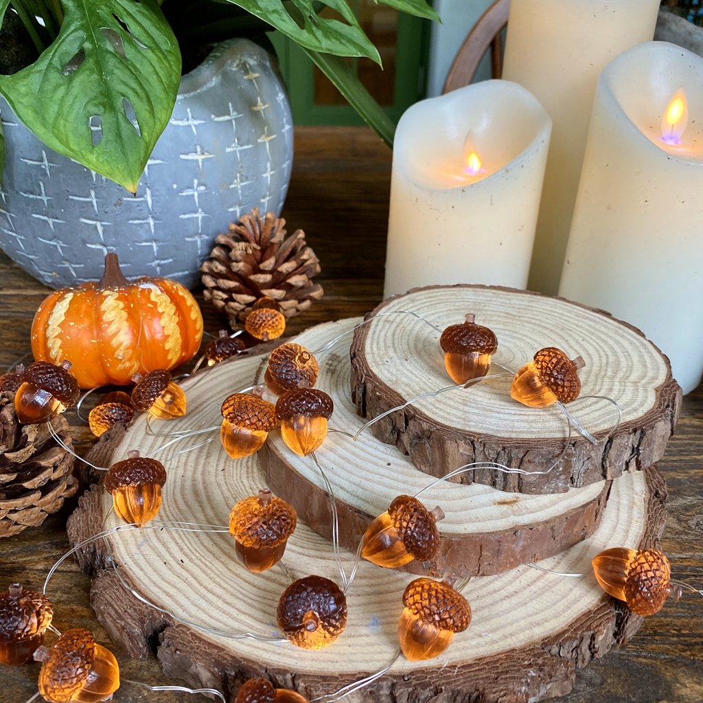 Acorn-shaped string lights with 30 LEDs on copper wire, arranged with pinecones, a pumpkin, and candles.