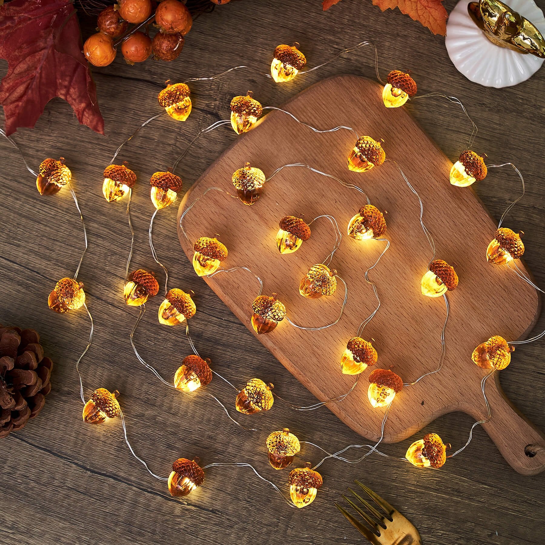 30 LED acorn-shaped string lights on a wooden surface with fall decor elements
