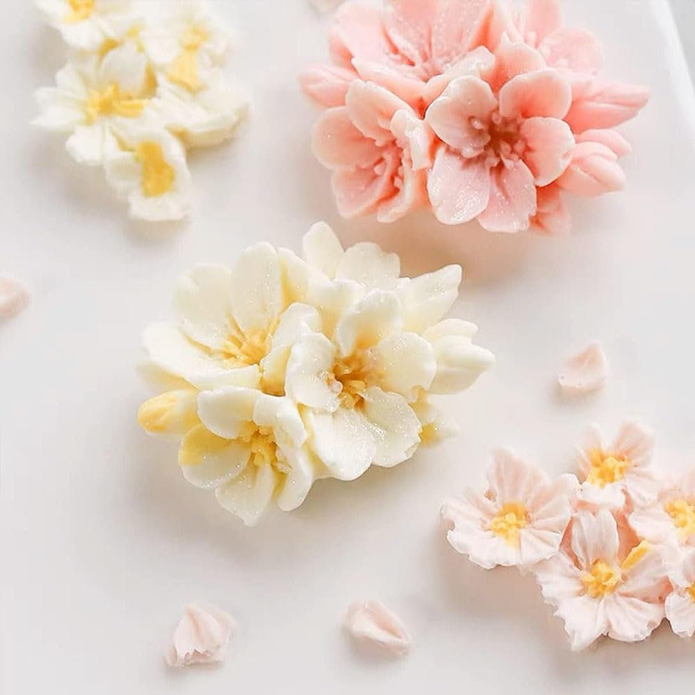 Close-up of white and pink cherry blossom flowers made from silicone mold on a white surface.