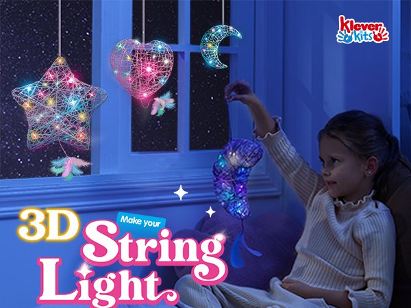 Girl holding a crescent moon string art light with star and heart shapes hanging in window