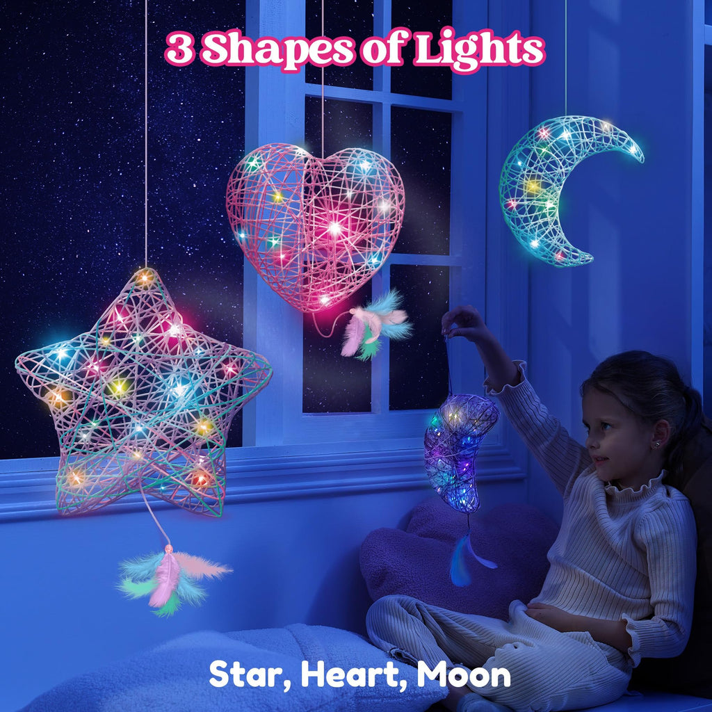 Girl holding a star-shaped string art light with feathers, heart and moon shapes hanging nearby.