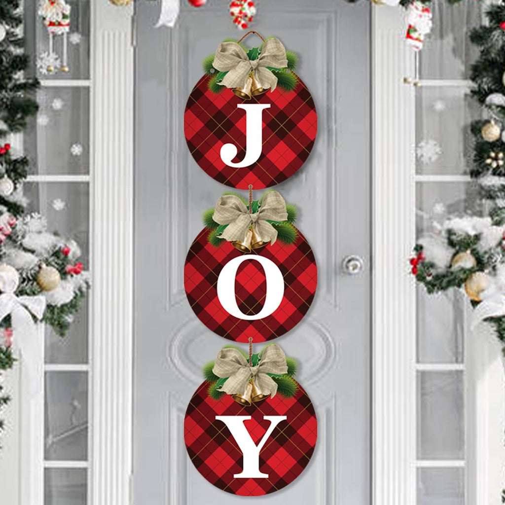 Three round buffalo plaid Christmas wreath signs spelling JOY, hanging on a door with festive decorations.