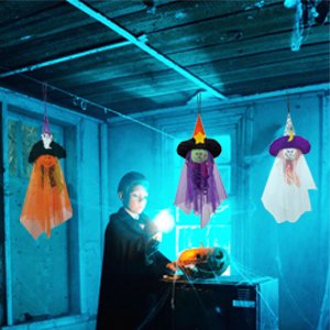 Three Halloween hanging ghost decorations with witch hats and capes, suspended from a ceiling indoors.