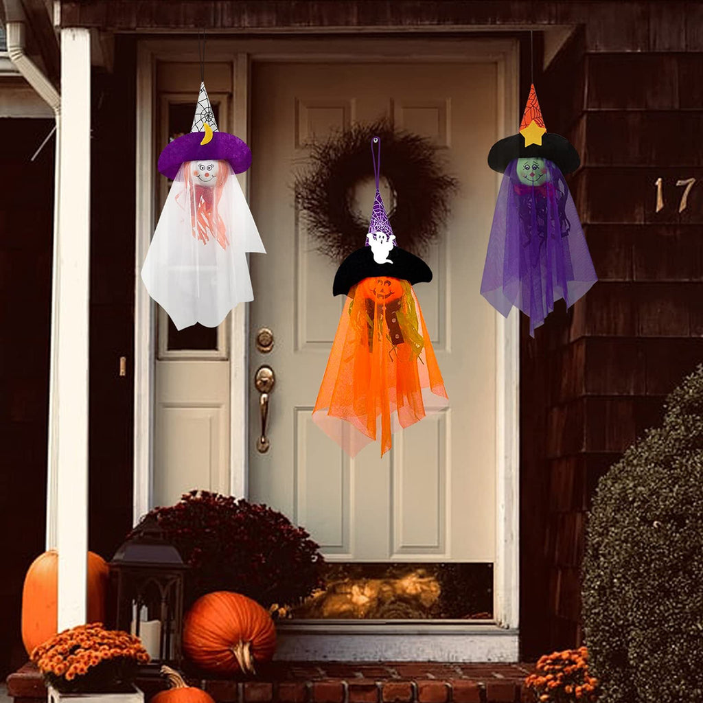 Three Halloween hanging ghost decorations with witch hats and tulle skirts displayed on a porch.