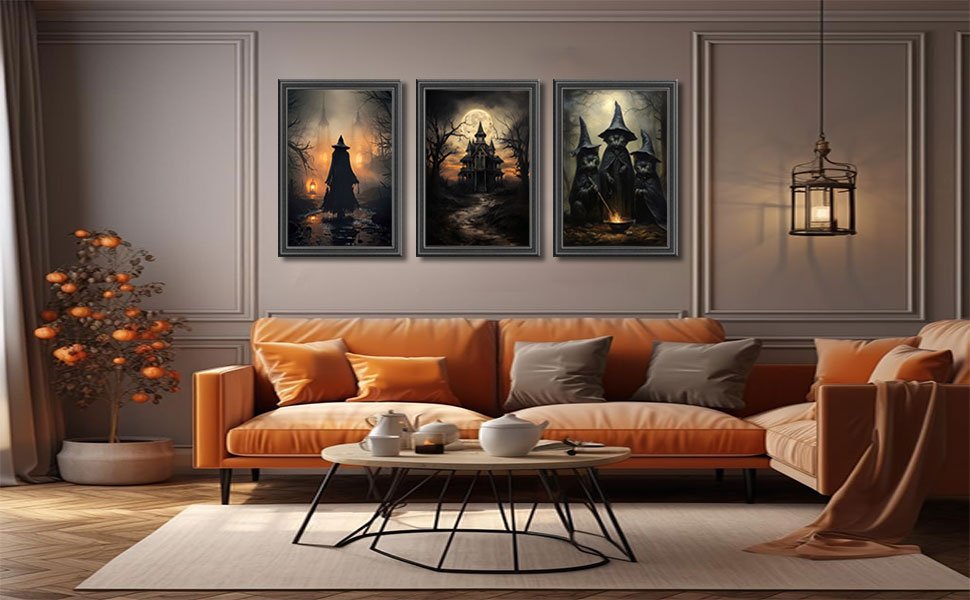 Three framed Halloween canvas art prints depicting witches and a haunted castle, displayed above an orange sofa in a living room.