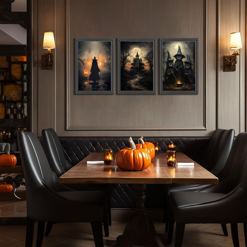 Three framed Halloween canvas art prints depicting witches and a haunted house, displayed above a dining table with pumpkins and candles.