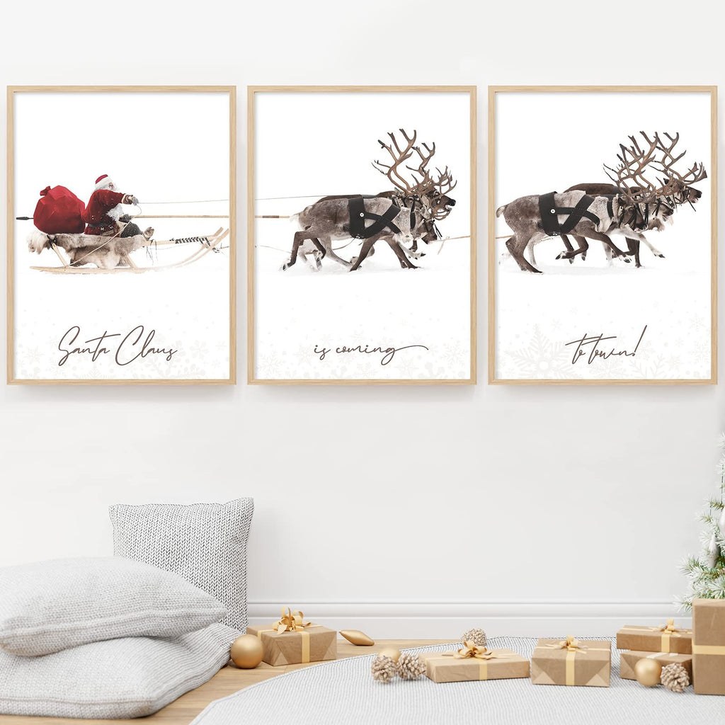 Three framed Christmas art prints showing Santa Claus with reindeer in the snow, with text overlays.