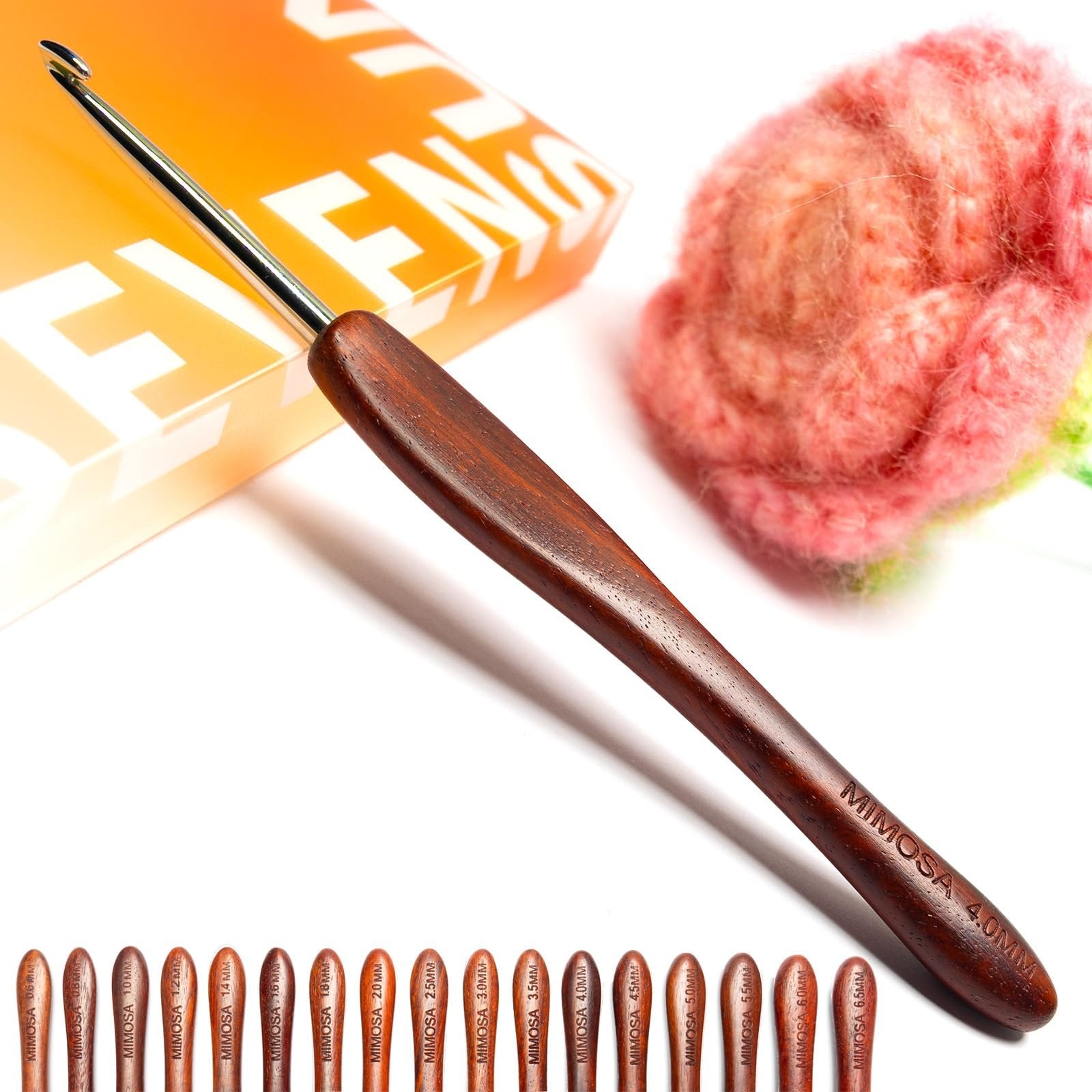 Ergonomic crochet hook with a wooden handle and stainless steel tip, shown with a ball of yarn and a box.